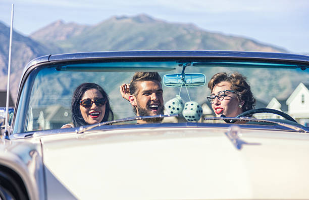 flirta con tre amici negli anni cinquanta auto classiche decapottabili - kitsch car retro revival sunglasses foto e immagini stock