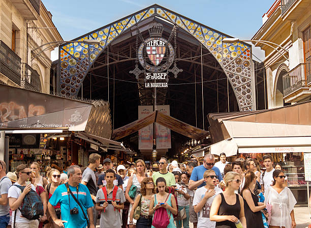 La Boqueria market Barcelona, Spain - July 6, 2015: Main gate at La Boqueria market. Market has been known since 1217. Now - one of the city's foremost tourist landmarks. People near an entrance of market. la rambla stock pictures, royalty-free photos & images