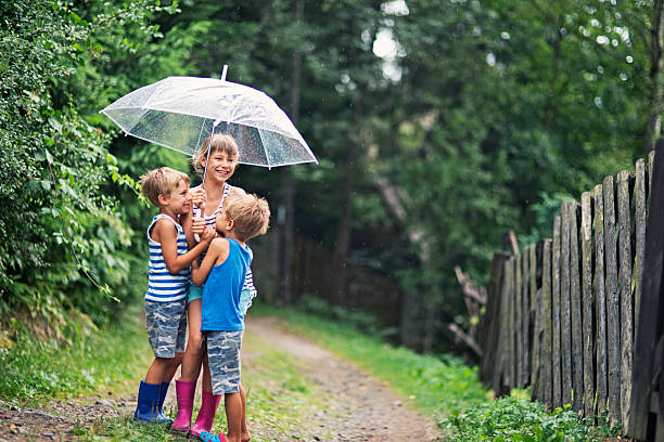 istock Kids with umbrella enjoying rain. 482736410