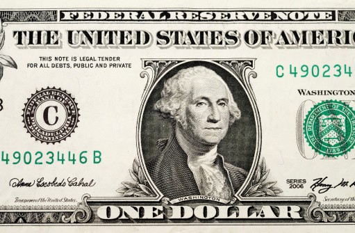 Partial view of a USA one dollar bill showing portrait of George Washington and phrase: 