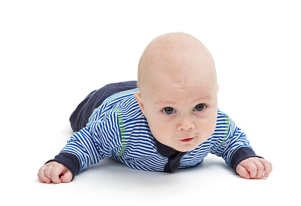 attentive baby laying on ground stock photo