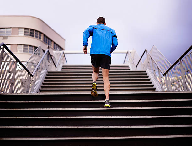 young athletic sportsmen running down stone stairs outdoors in the morning