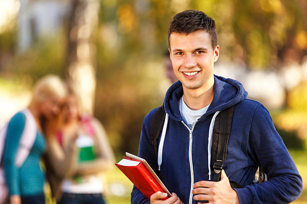 studente di college con libro e tavoletta digitale all'aperto - university freshman portrait teenager foto e immagini stock