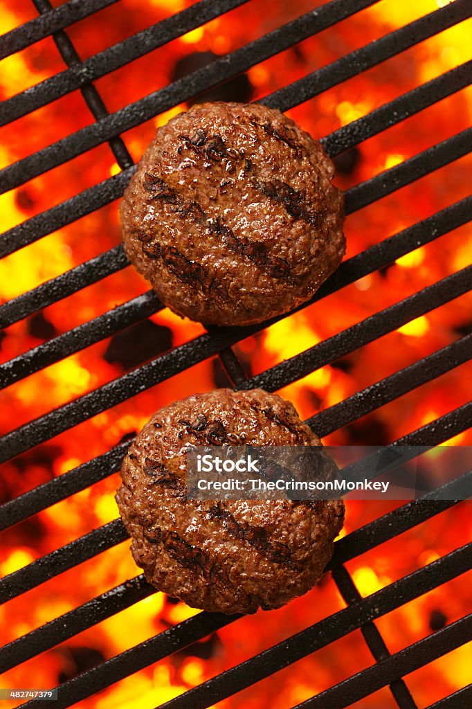Grilled Hamburgers Two hamburgers sizzling on a grill. Barbecue Grill Stock Photo