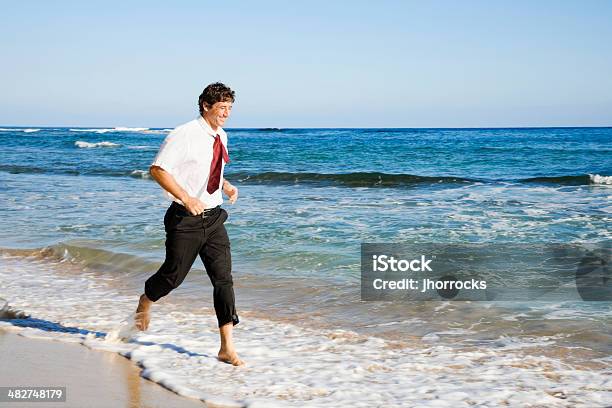 Uomo Daffari Corre A Piedi Nudi Sulla Spiaggia - Fotografie stock e altre immagini di Abbigliamento elegante - Abbigliamento elegante, Adulto, Affari