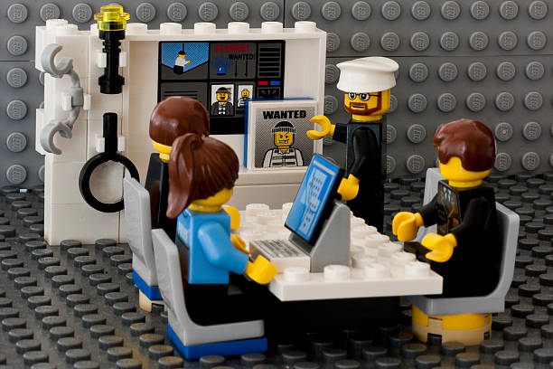 meeting room police brugstraat, Aalter, Belgium - march 12th 2012: police Lego figures in a police room invetigating a murder.  Shot in home studio. focus in total.  baby gun stock pictures, royalty-free photos & images
