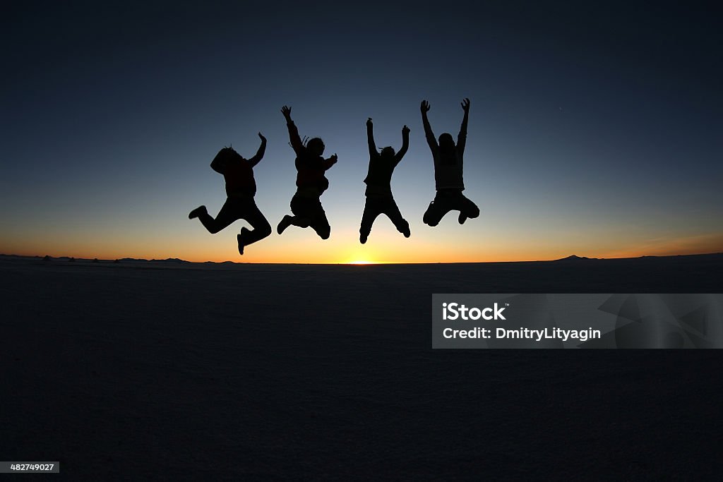 Amici felici saltando all'aperto - Foto stock royalty-free di Festeggiamento