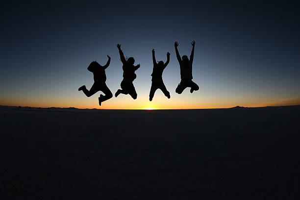 A group of happy young friends jumping in Solar de Uyuni, Bolivia