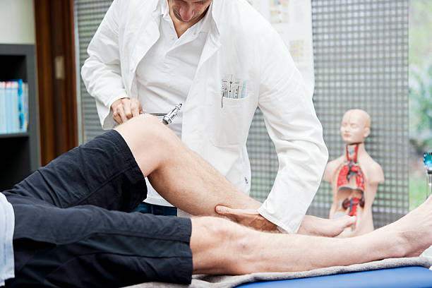 Doctor testing patellatendon`s reflex A  medicine, testing the patella tendon`s reflex of a patient.  orthopedist stock pictures, royalty-free photos & images