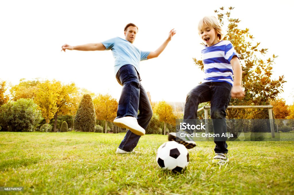Отец и сын, играющий в футбол - Стоковые фото Футбол роялти-ф�ри