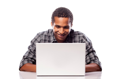 happy and smiling dark-skinned student posing with his laptop