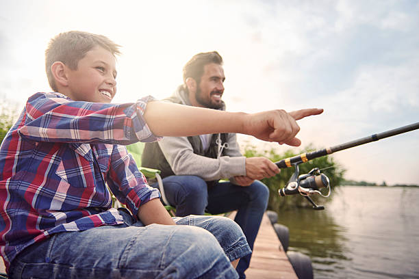 Daddy look! There is a big fish! Daddy look! There is a big fish! fishing rod photos stock pictures, royalty-free photos & images