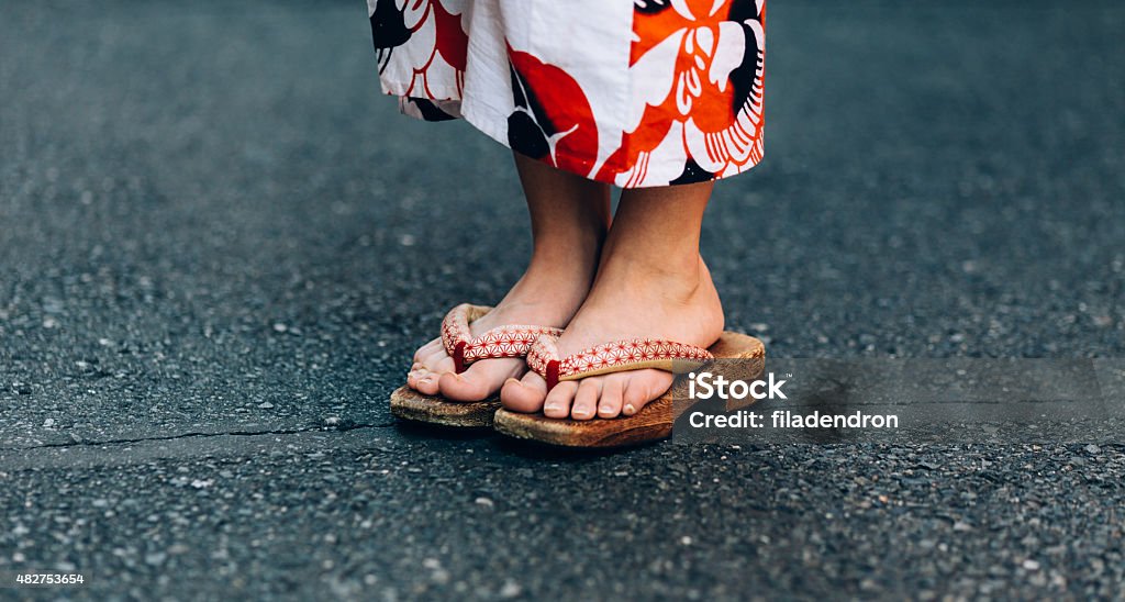 Traditional japanese Zori Beautiful female feet wear a traditional japanese Zori. Geta Sandal Stock Photo