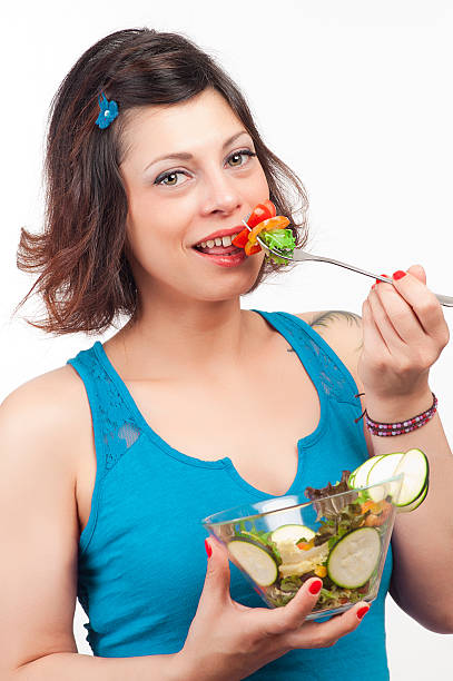 istock brunette girl eating salad 482756666