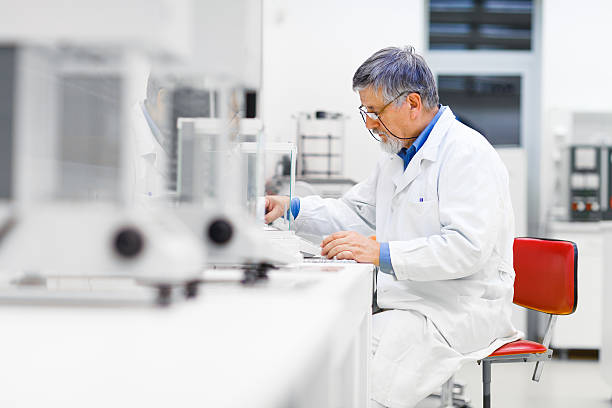 investigador senior masculino llevando a cabo investigaciones científicas en un laboratorio - scientist lab coat doctor male fotografías e imágenes de stock