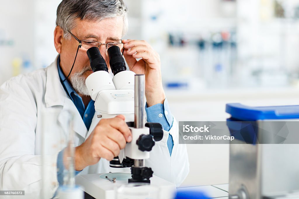 Senior male researcher carrying out scientific research in a lab Senior male researcher carrying out scientific research in a modern lab, preparing chemical compounds, using microscope, scales and other high-tech laboratory equipment (shallow DOF; color toned image) 2015 Stock Photo