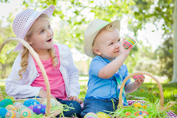 istock Cute Young Brother and Sister Enjoying Their Easter Eggs Outside 482764155