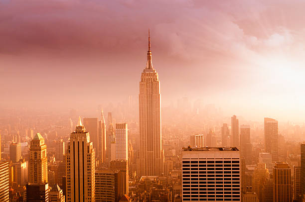 new york city skyline bei sonnenuntergang - empire state building urban scene new york state new york city stock-fotos und bilder