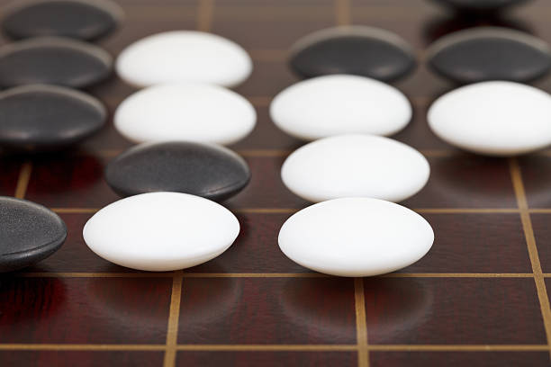 istock stones during go game playing on wooden desk 482767113
