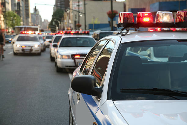 Police Cars On Street Row of police cars with flashing lights and sirens on the streets of Manahttan, New York City, New York, USA. police car photos stock pictures, royalty-free photos & images