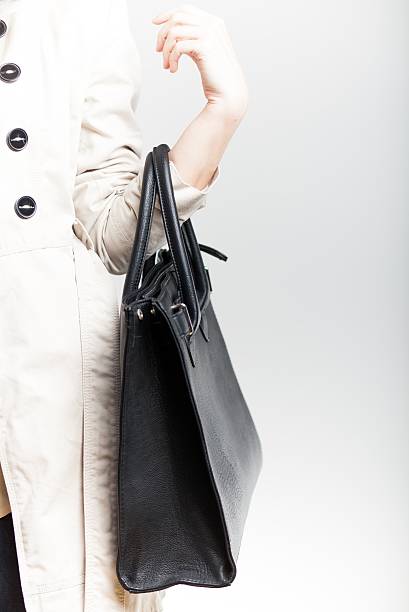 istock Elegant woman in coat with black leather bag 482767733