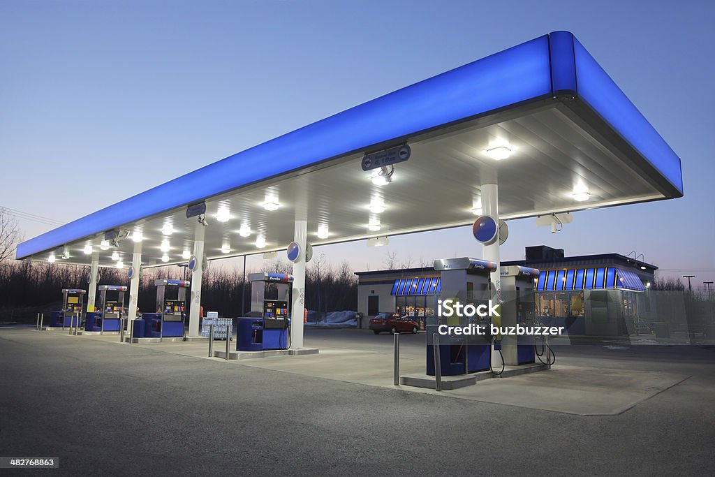 Illuminated Blue Gas Station at Sunset  Gas Station Stock Photo