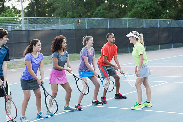 istock Teenagers with tennis coach doing drills 482770026