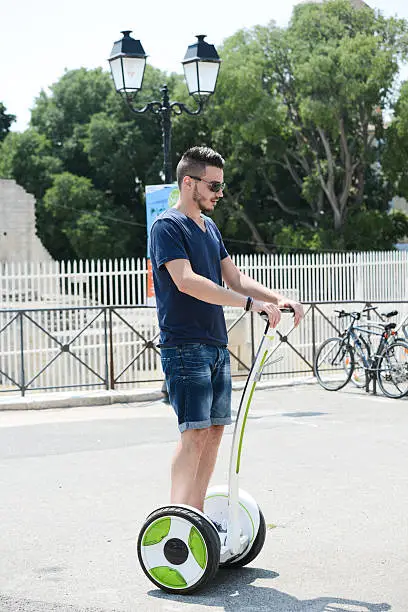 handsome young man riding segway gyropode electric two wheels vehicule on a sightseeing tour