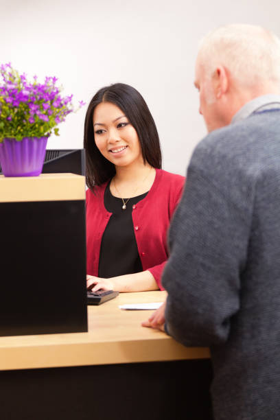 caixa de banco de serviço de cliente de comércio balcão de serviço bancário - bank teller bank check asian ethnicity imagens e fotografias de stock