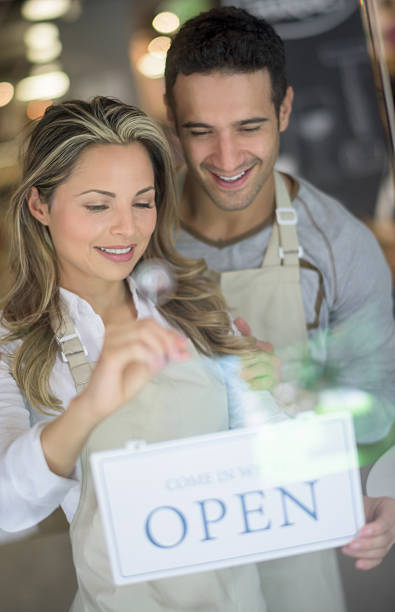 istock Couple working at a store and holding an open sing 482773504