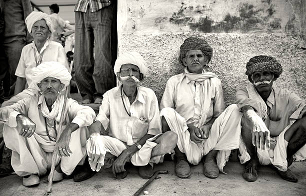 5 older men sitting in small village of Sabalpura in Rajastan. India.  Watching the procession of villagers partying - all are very handsome, elegant & wearing traditional clothing.