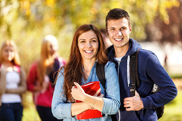 deux étudiants heureux en face du campus - smart casual outdoors friendship happiness photos et images de collection
