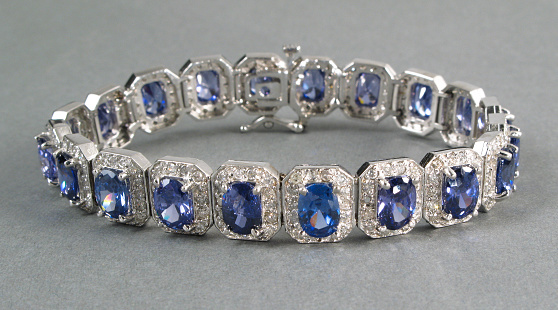 Expensive diamond and tanzanite bracelet on a gray background.