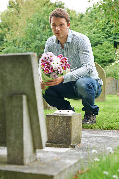 istock Man Laying Flowers At Grave 482785165