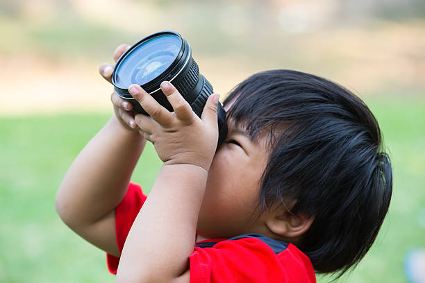 istock Cute little boy is taking pictures in field 482785461
