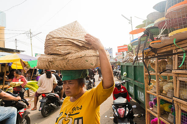 balinese donna equilibri cesti intrecciati sulla testa tradizionale mercato indonesiano - service occupation candid small business carrying foto e immagini stock