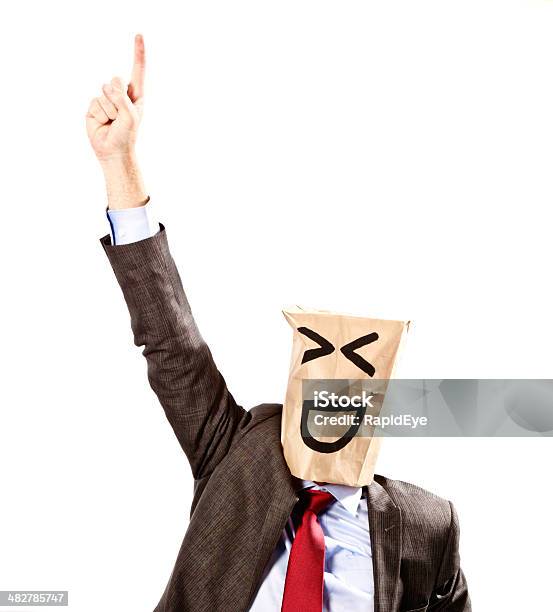 Businessman In Paperbag Mask Points Upwards Laughing Stock Photo - Download Image Now