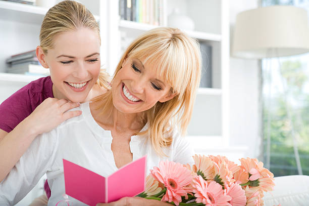 Daughter giving her mother a gift stock photo