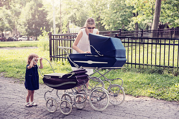 istock Mother and daughter walking babies in vintage prams. 482787072