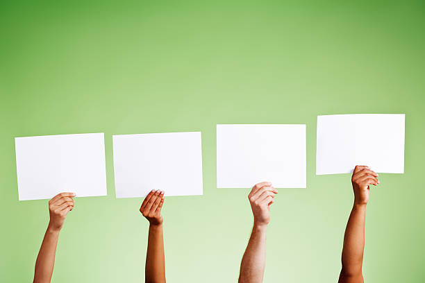 istock Four hands hold up blank placards, ready for your message 482787307