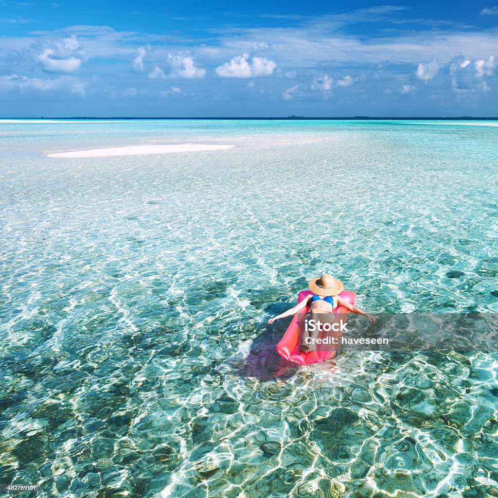 Woman relaxing on inflatable mattress Woman relaxing on inflatable mattress at the beach Adult Stock Photo