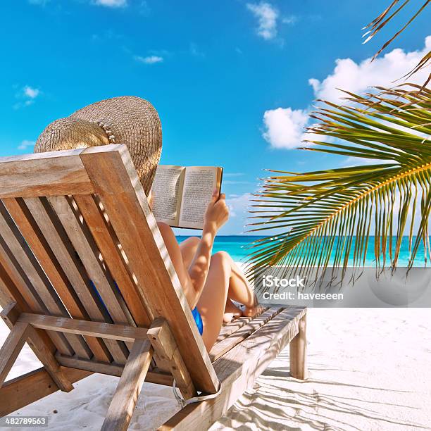 Young Woman Reading A Book At Beach Stock Photo - Download Image Now - Adult, Beach, Blue