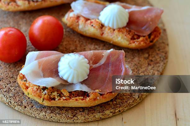 Bruschetta With Oregano Prosciutto And Mozzarella On A Wooden Table Stock Photo - Download Image Now