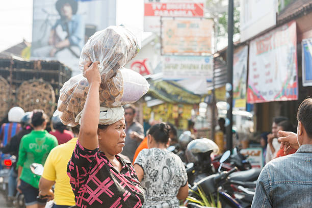 balinese donna equilibri zucchero di palma sulla testa tradizionale mercato indonesiano - service occupation candid small business carrying foto e immagini stock