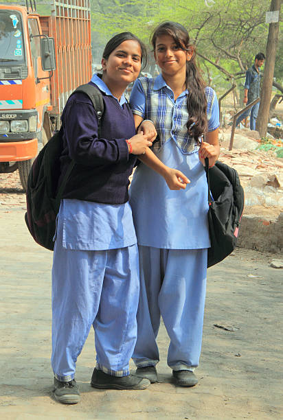 duas meninas na escola roupas são sorrindo para alguém - india slum poverty family - fotografias e filmes do acervo