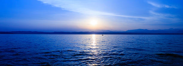 パノラマに広がる風景、湖で夕日 - lake garda sunset blue nautical vessel ストックフォトと画像