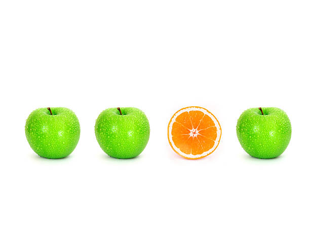 istock sliced orange place on white background among green apple 482798296