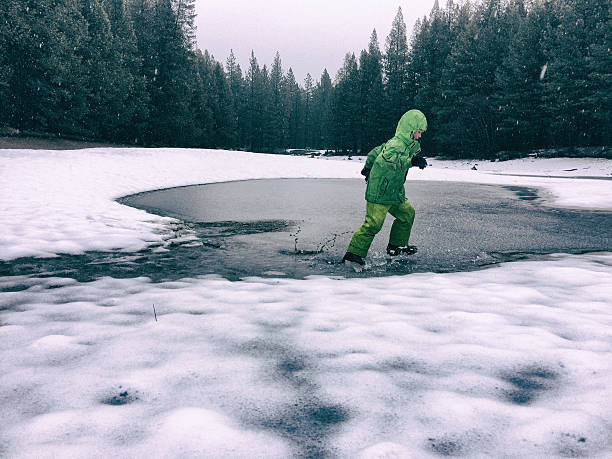 chłopiec rozbijające się na oblodzonych pond - cold stamping zdjęcia i obrazy z banku zdjęć