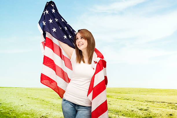 istock Smiling woman holding American flag 482799549