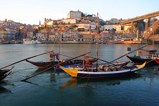 Oporto "postcard" -  Portugal Oporto city, two "Rebelo" Boats in the river (Douro) at sunset framed by the old city and the "D. Luis" bridge, Portugal. rabelo boat stock pictures, royalty-free photos & images